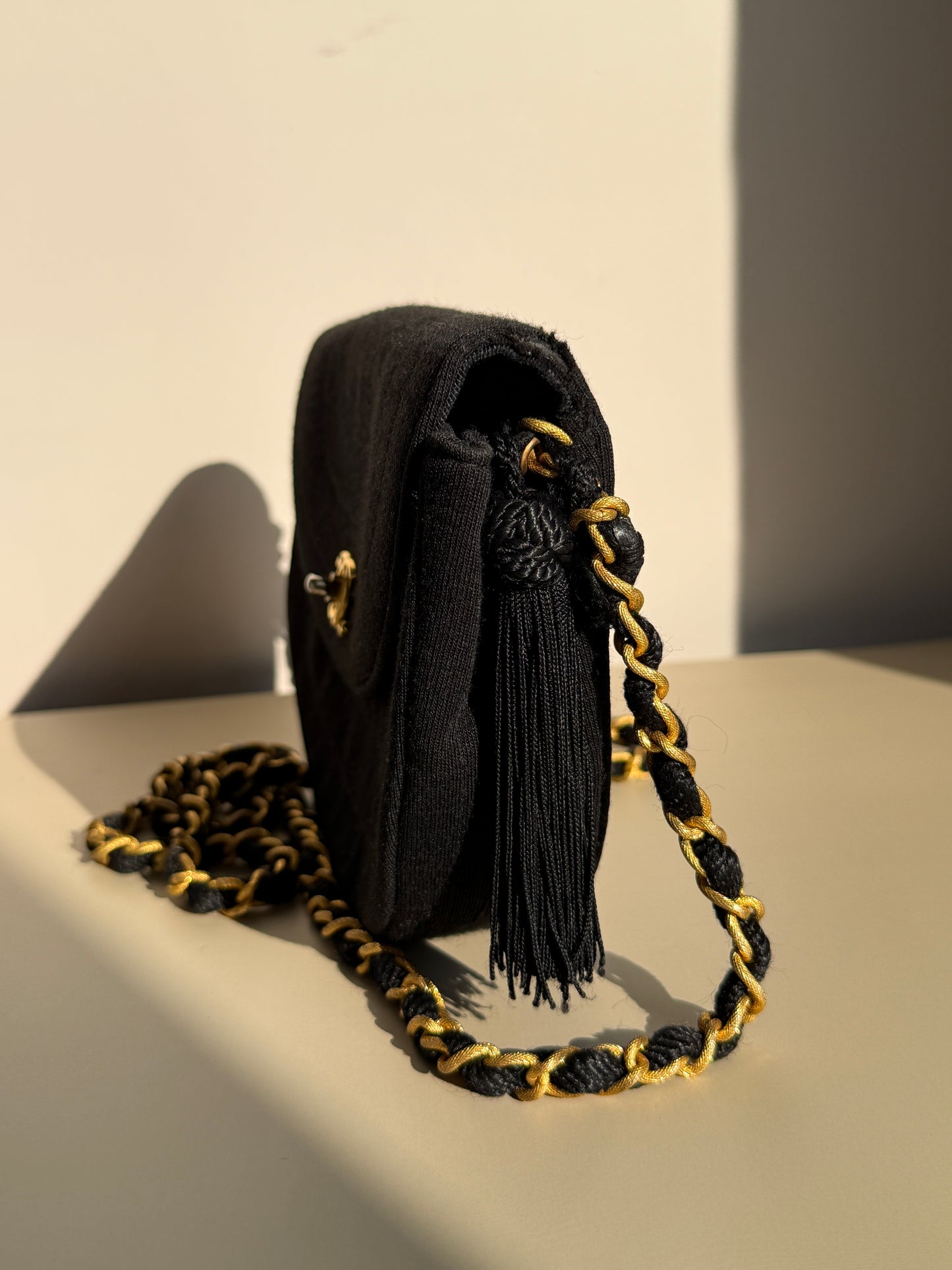 Chanel – Pochette en tissu matelassé noir avec chaîne dorée