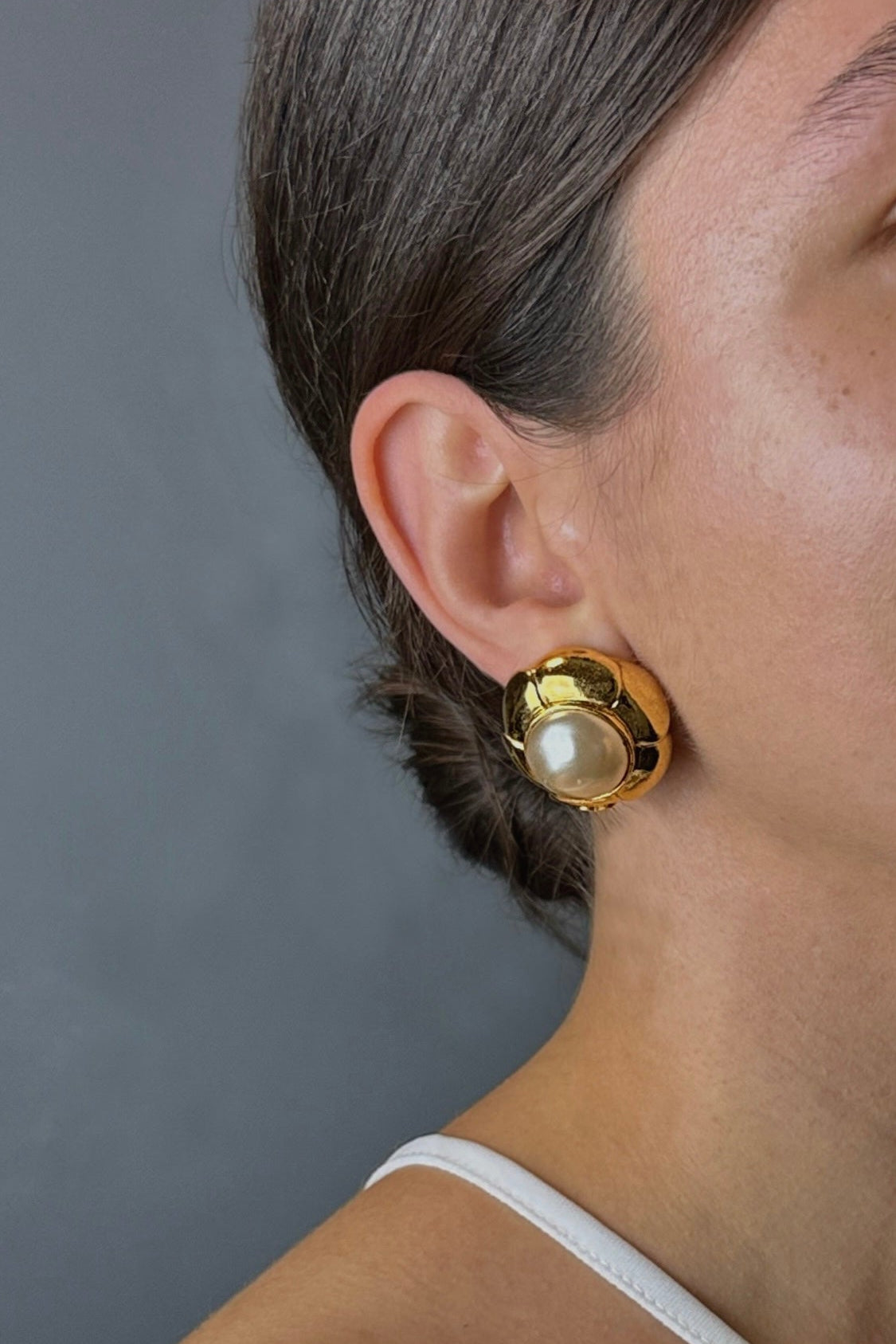 Zoom sur clip d’oreille Chanel vintage doré avec perle baroque porté à l’oreille