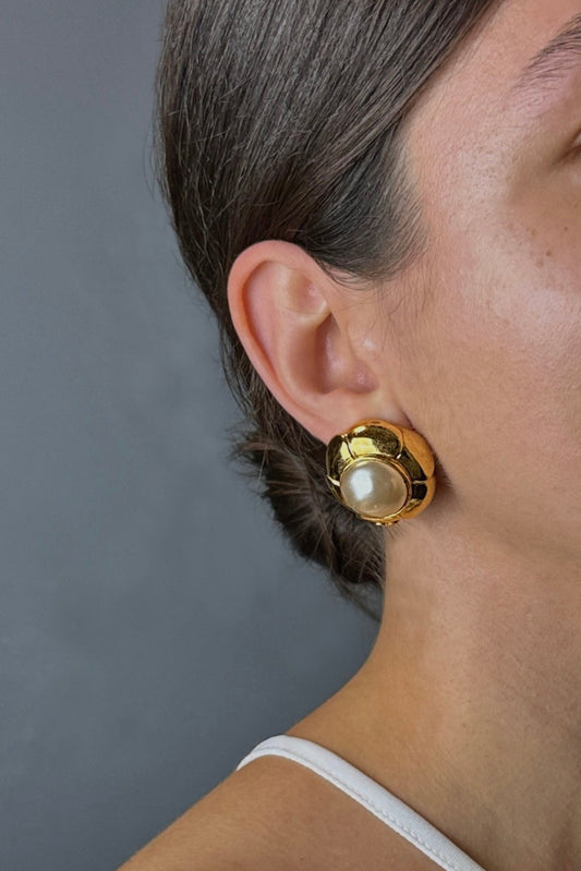 Zoom sur clip d’oreille Chanel vintage doré avec perle baroque porté à l’oreille