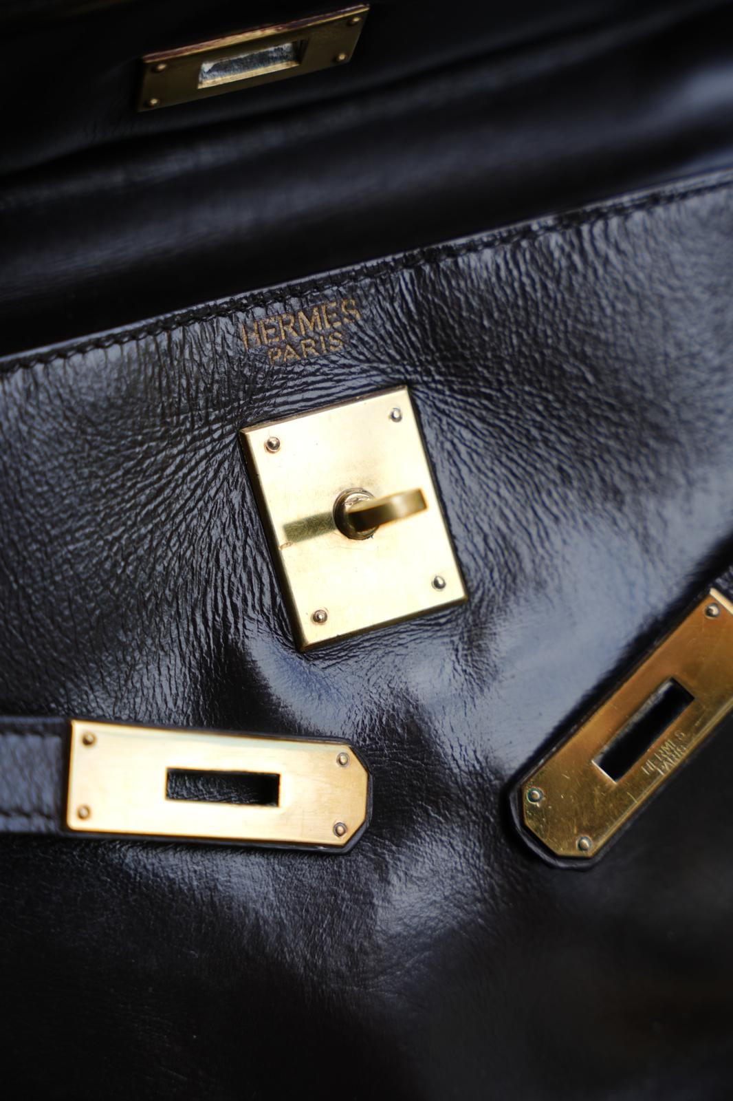 Détail du marquage sur cuir et du fermoir intérieur d’un sac kelly Hermès vintage marron avec éléments métalliques dorés