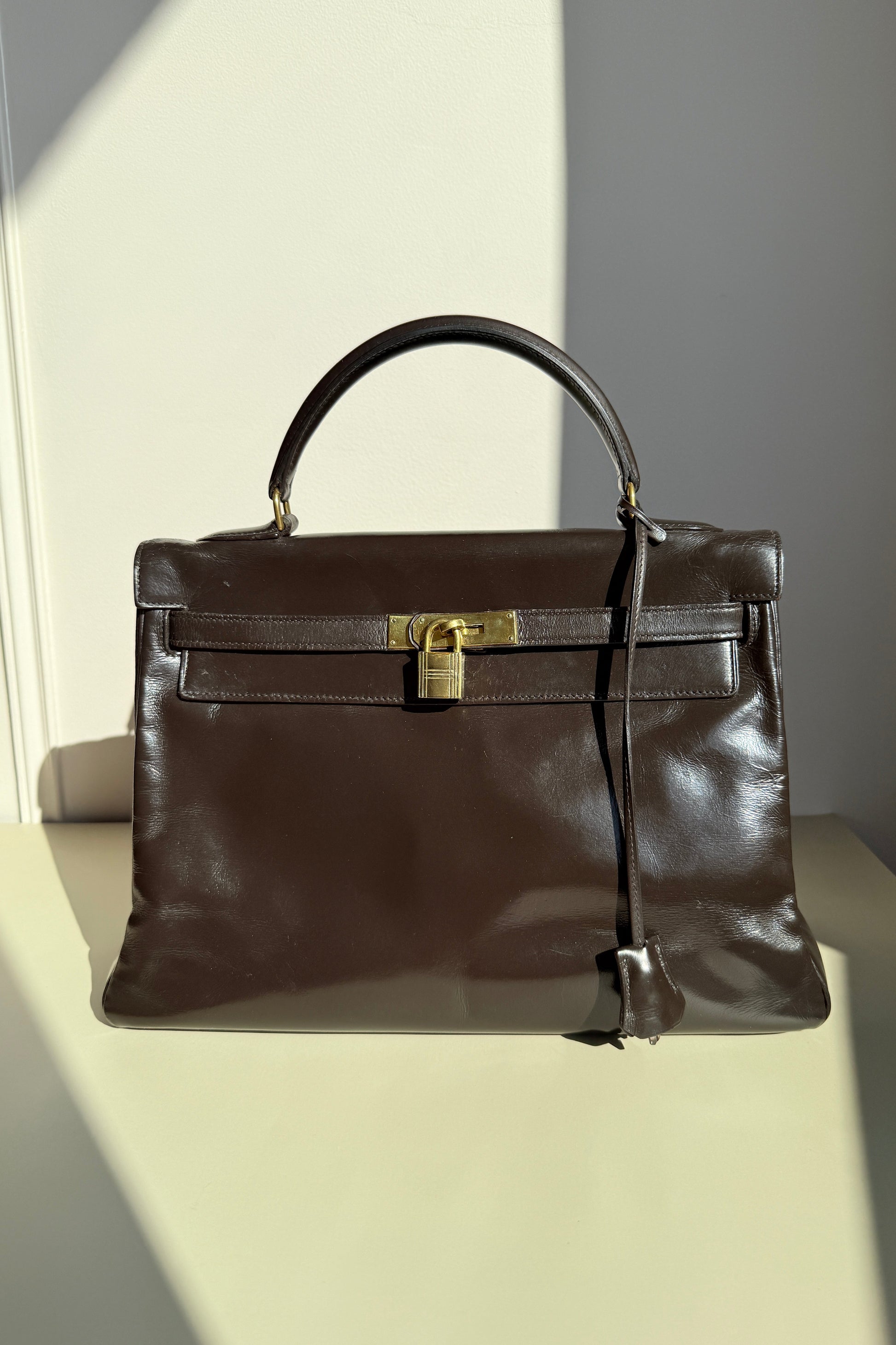 Sac kelly vintage Hermès marron fermé avec cadenas, avec éléments métalliques dorés