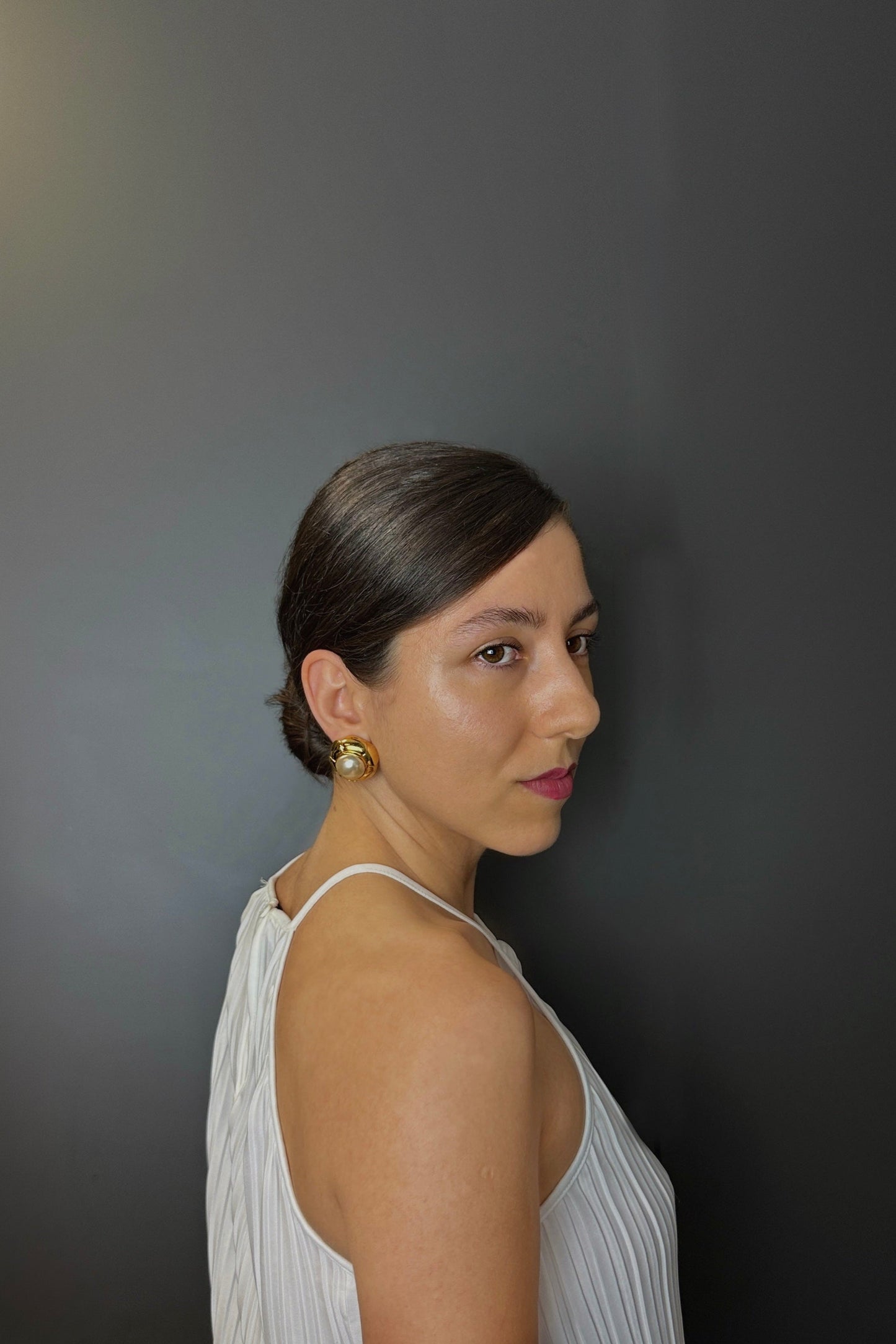 Clips d’oreilles Chanel vintage portés, perle baroque blanche et métal doré, style élégant.