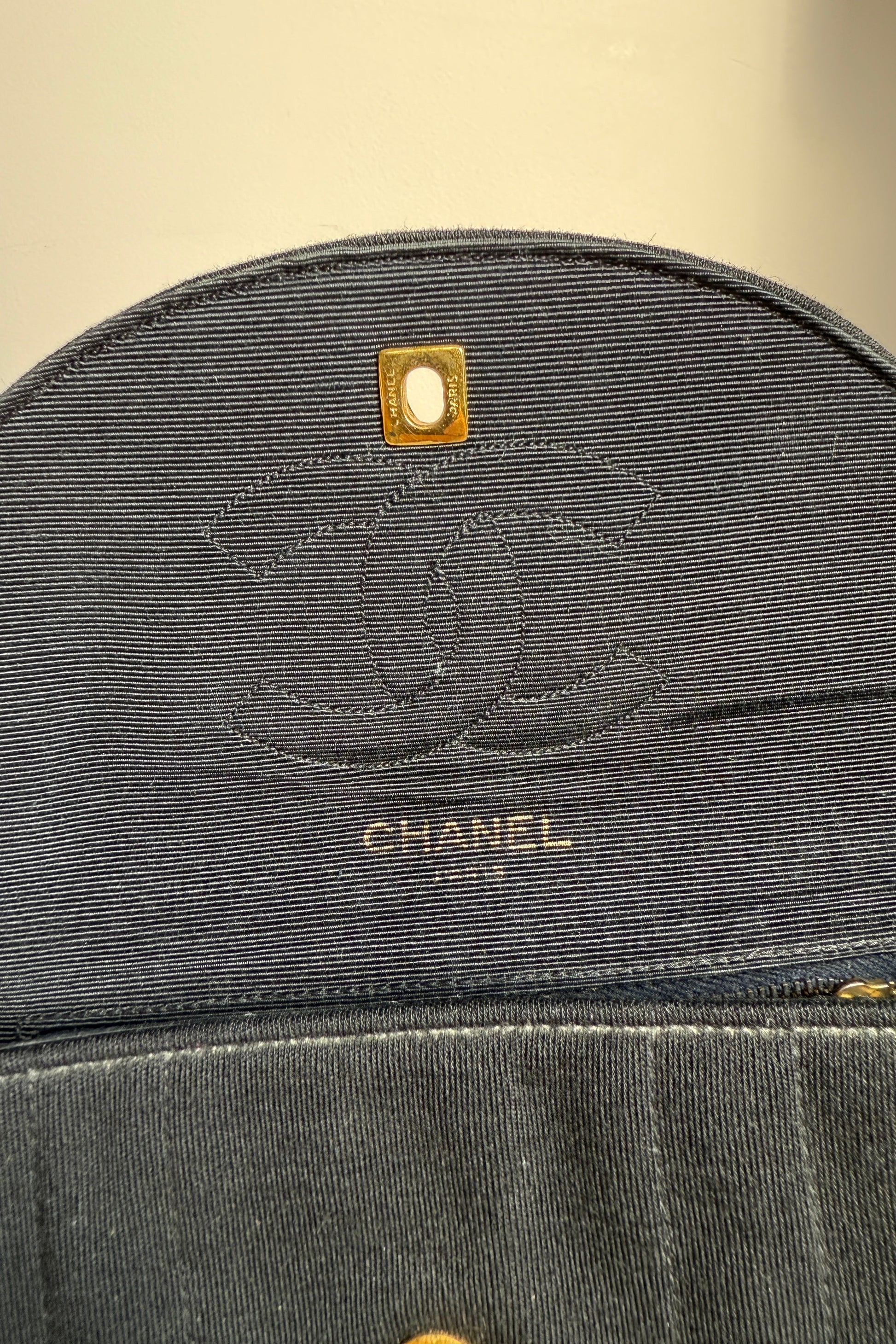 Détail du sac Chanel noir, logo CC sur rabat ouvert